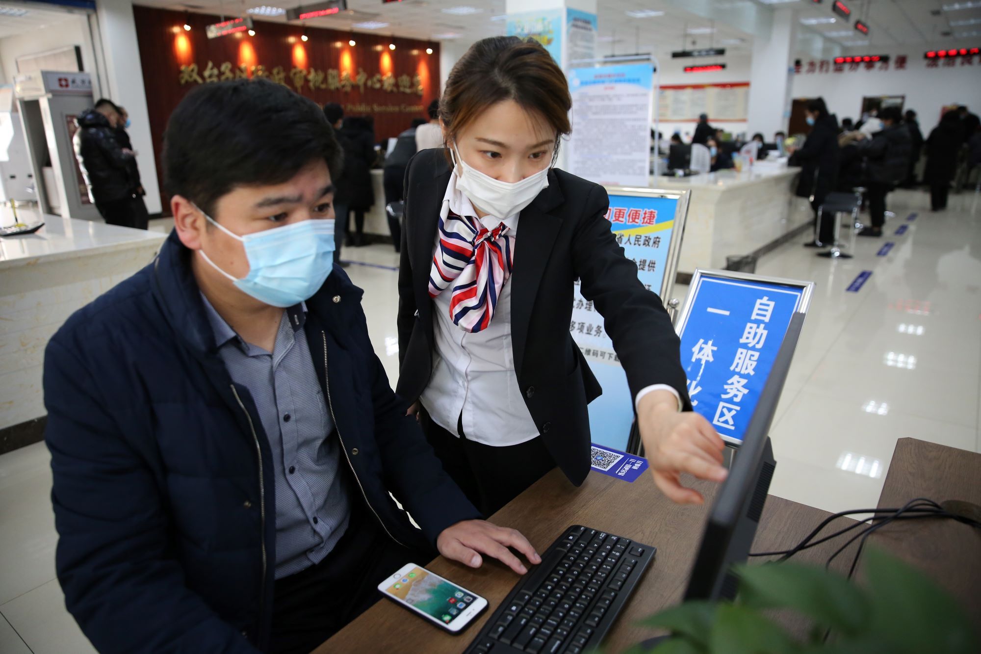 双台子区行政审批服务中心工作人员帮助群众办理个人申报事项。（摄影：刘立杉）