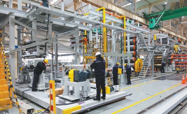 大连重工装备集团工人正在装配大型橡塑装备。（摄影：王荣琦）