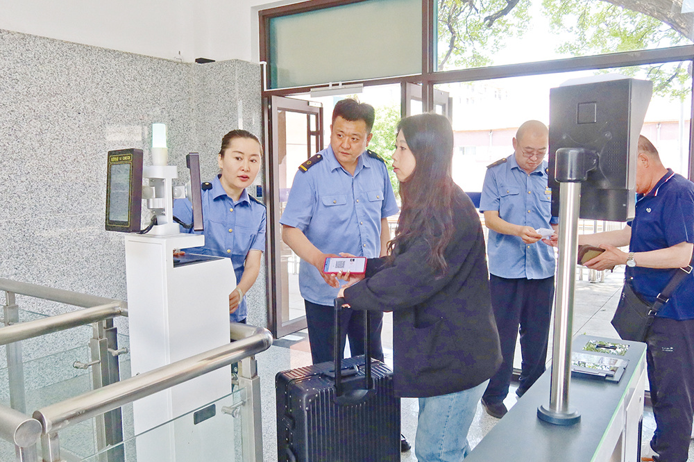 五龙背火车站新站舍启用首日,旅客依次通过自助检票闸机。(周广庆 摄)