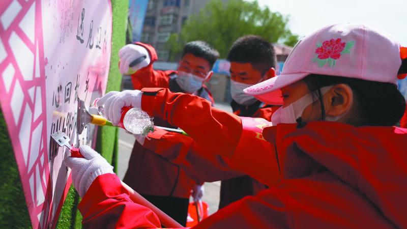 太子河区新时代文明实践中心组织志愿者清理小广告小招贴。(摄影:苑健聪)