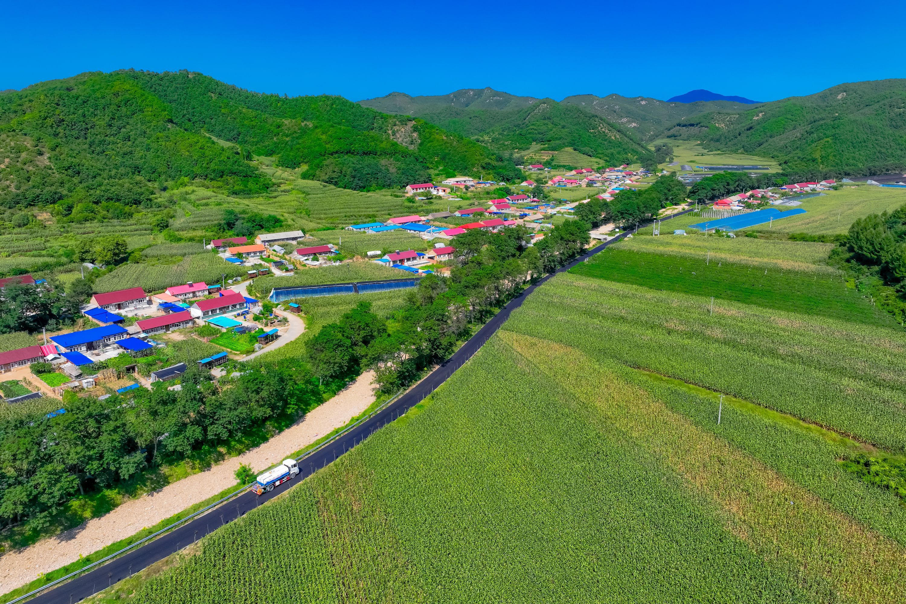 庄河市桂云花乡三道岭村的上窑线路面铺设进入收尾阶段。
