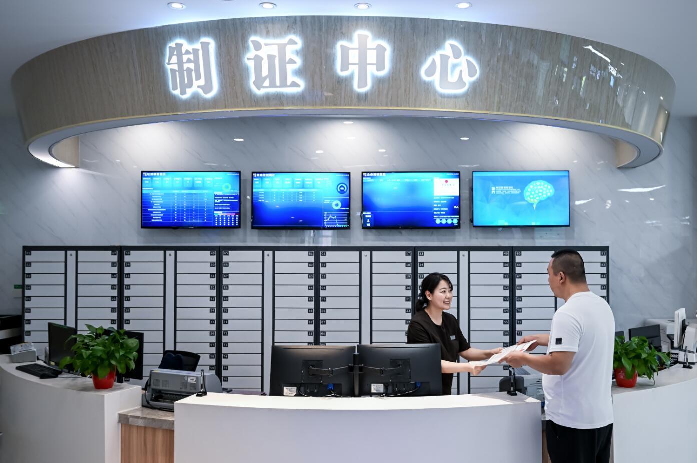 沈抚示范区政务服务中心内,工作人员向群众递上刚办结的证件。