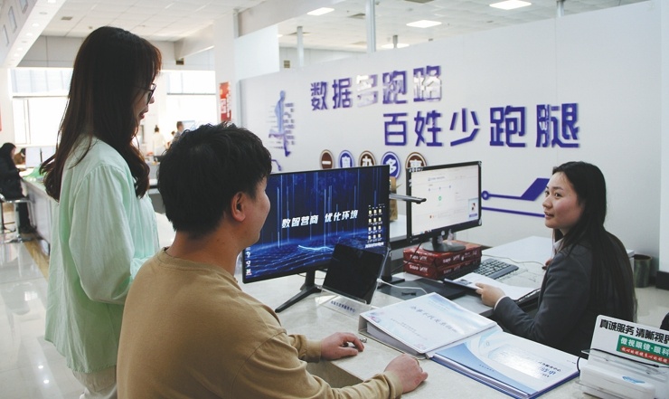 海城市公共行政服务中心工作人员正细心地为企业代表办理手续。(摄影:崔治)
