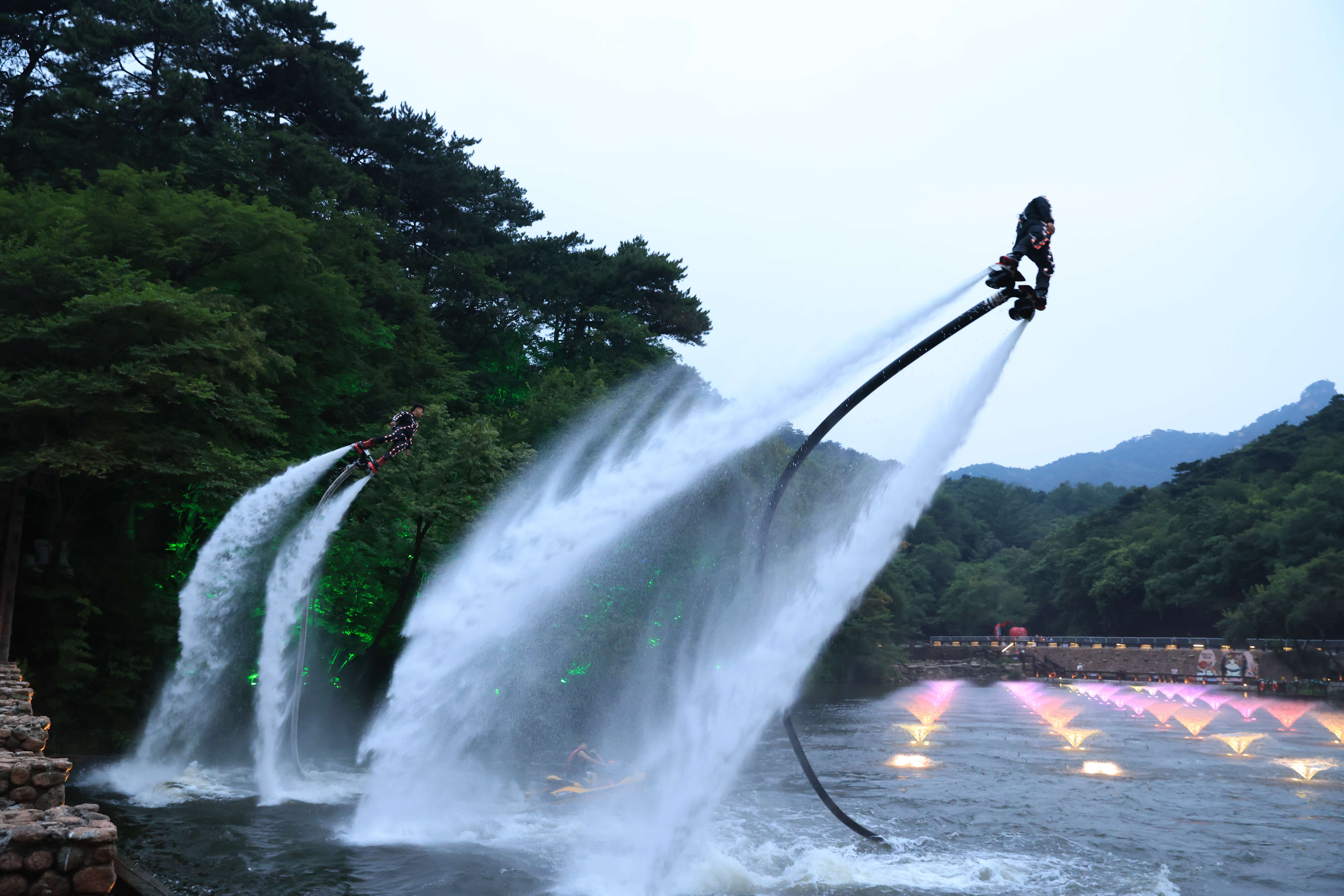 千山景区云潭湖畔，水上空中飞人表演正在进行。（来源：辽宁千山旅游集团）