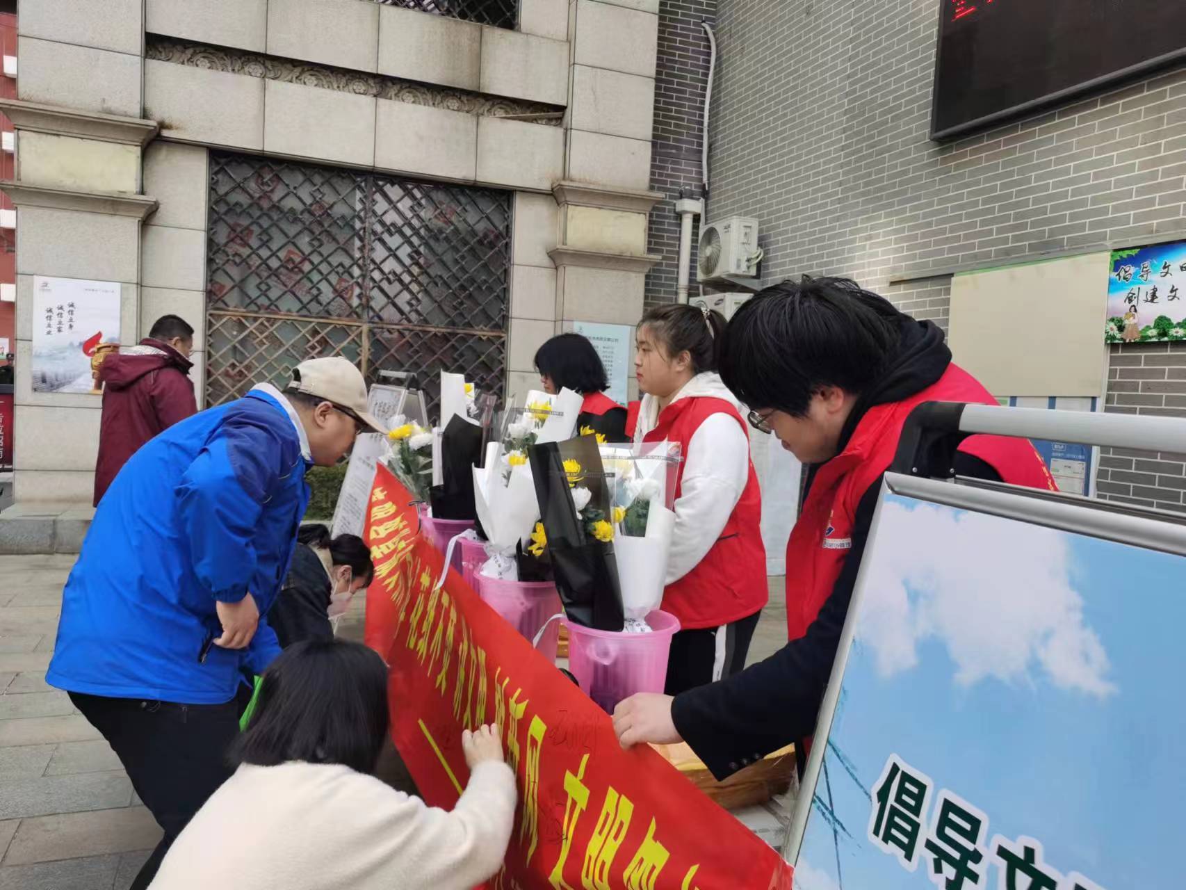 小区居民在文明祭祀宣传横幅上签名