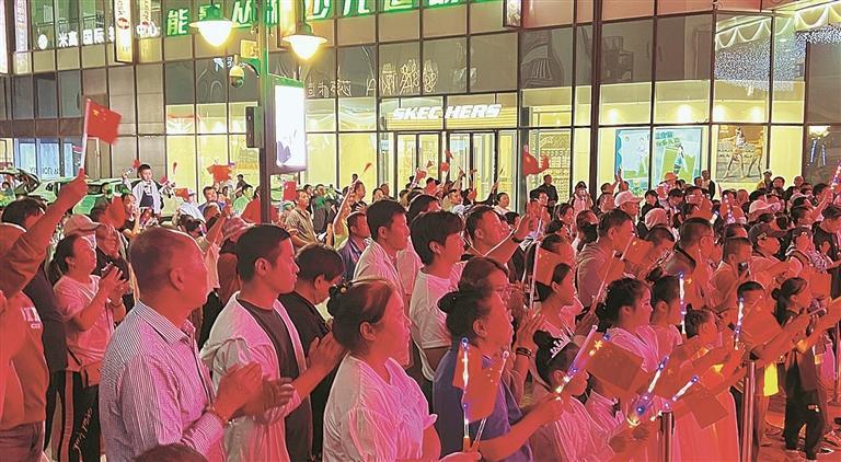 天津街上举行的国庆主题歌会吸引众多市民游客观看。(摄影:杜杨楠)