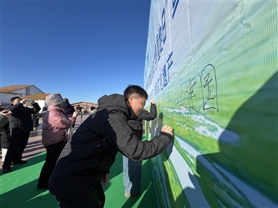 参加活动人员在签名板上签名。