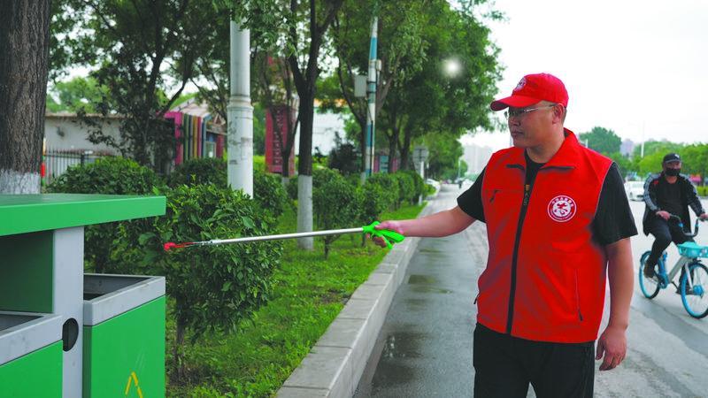 太子河区机关干部走上街头,清理路面及绿化带。(摄影:苑健聪)