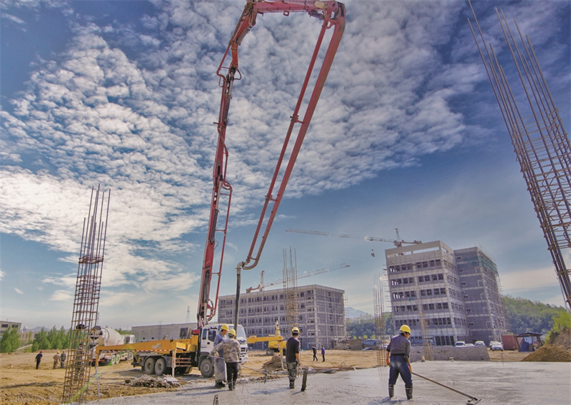 辽宁锦河药业有限公司新建项目工地，工人正在浇筑混凝土地基。