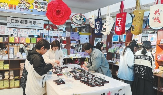 游客在文创用品店购物、盖纪念章。(摄影:姜帆)