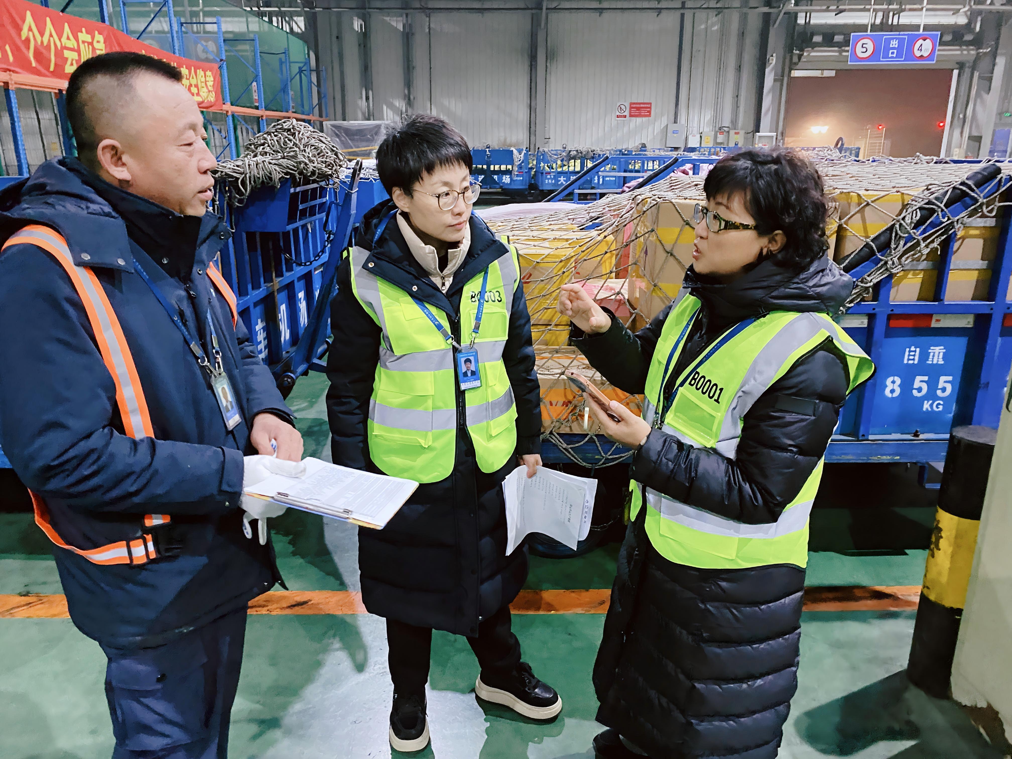 记者吕丽（右）于凌晨4点在大连机场货运库区采访当天第一批货物如何“拼”上飞机。 （摄影：王勋）