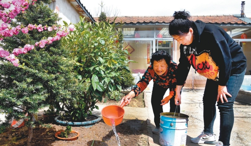 瓦房村村民陈广珍和女儿杨楷英栽花种草，美化庭院。（摄影：宋永昆）