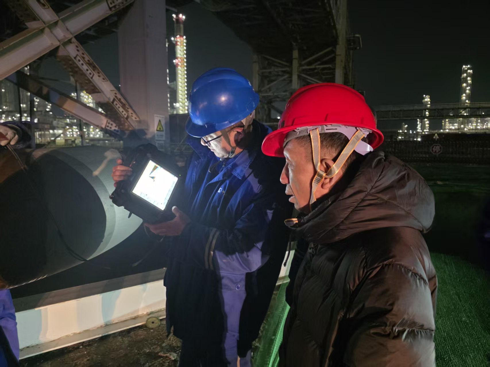 记者刘永安（右）在华锦阿美超声检测作业现场采访。 （摄影：刘沐欣）