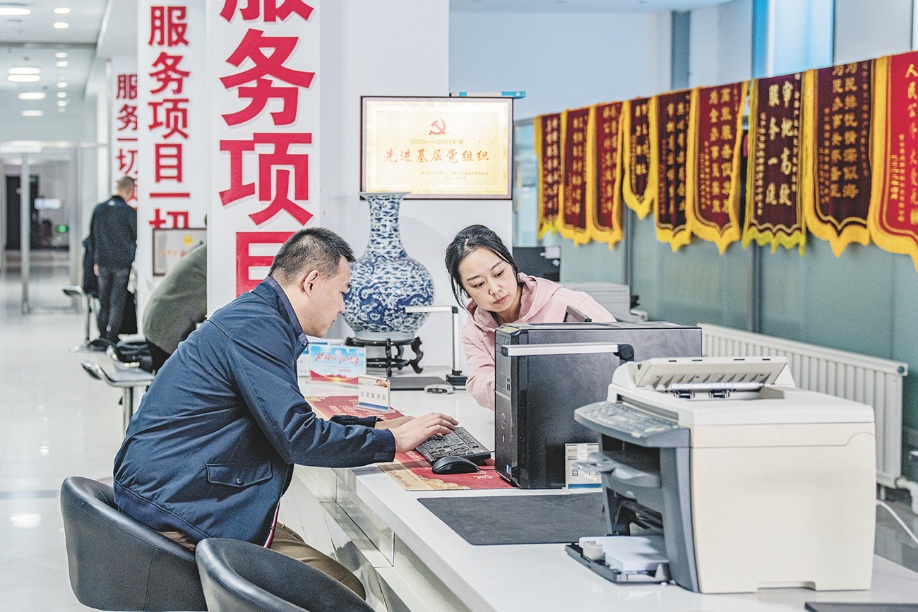 辽宁（营口）沿海产业基地政务服务中心工作人员（右）为办事企业耐心讲解。（摄影：李国颖）