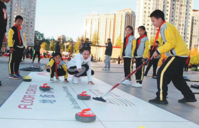 丹东小学生体验陆地冰壶运动。