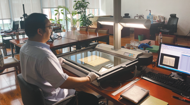辽宁省图书馆古籍文献中心工作人员正在扫描古籍。（摄影：杨 竞）