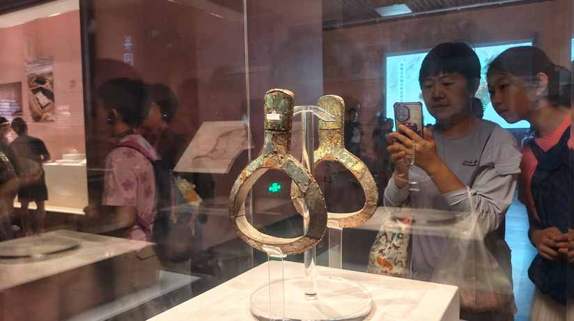 一位家长用手机记录精美的辽博展品。