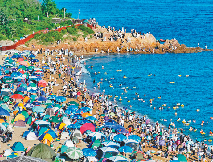 图为在大连傅家庄海滨浴场,游客充分享受夏日海滨的美好时光。