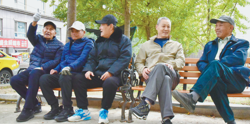 丹东的退休老人在社区爱心座椅上休息聊天，尽享舒适宜居生活。 张怡媛 摄
