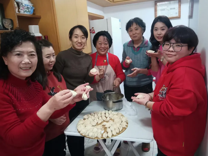 潘玉华（左一）与街坊邻居一起包饺子。