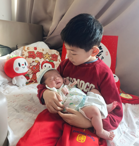 沈阳市妇婴医院家庭化产房内，哥哥抱着新出生的妹妹。 受访单位供图