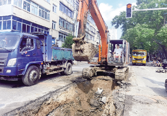 图为7月18日，在锦山大街与兴七路路口，市政工作人员更换排水管道。